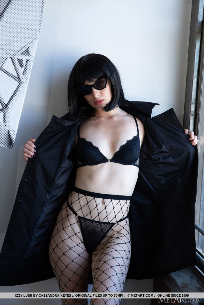 Izzy Lush unfastens her black coat and brings into the open her super hot body in black lace lingerie plus a fishnet pantyhose and high heels that accentuate her sexy legs.